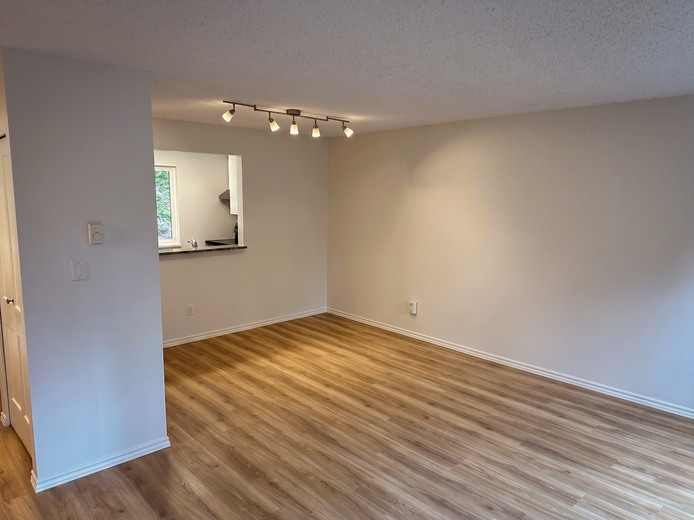 Renovated townhome living room showing modern flooring and kitchen pass-through