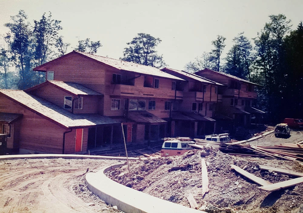 Townhome blocks with cedar siding during final framing and roof installation